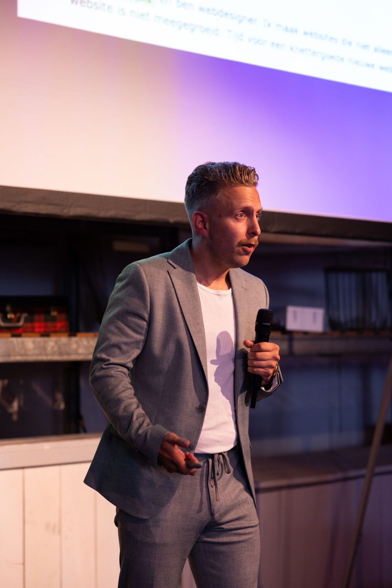 Spreker vertelt over websites op het podium