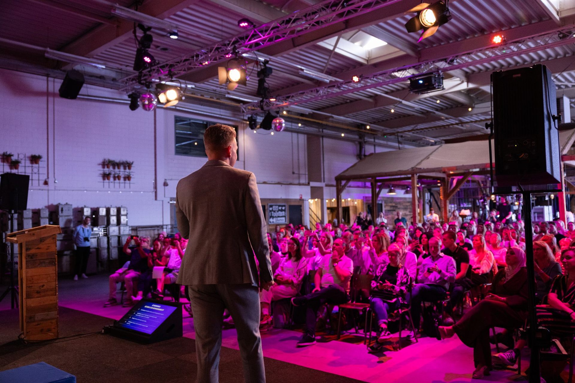 Spreker voor een vol publiek in de zaal